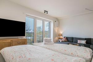 a bedroom with a bed and a flat screen tv at Husbyries Wohnung 11 in Husby