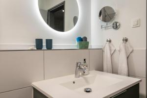 a white bathroom with a sink and a mirror at Husbyries Wohnung 11 in Husby