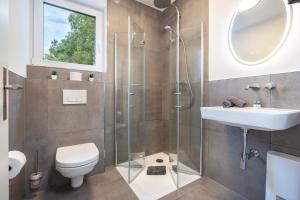a bathroom with a shower and a toilet and a sink at Egge Resort 7g mit Whirpool u Sauna in Altenbeken +21 photos