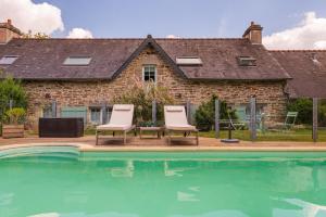two chairs sitting next to a swimming pool at Longère de Nivinen in Arzano