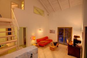 a living room with a red couch and a table at Villa Asterias Ideales Resort in Kefallonia +17 photos