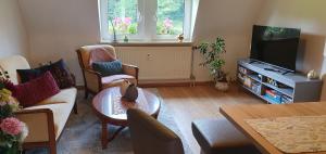 a living room with a couch and a tv at Fewo D und R Schwesternherz in Naumburg