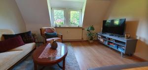 a living room with a couch and a tv at Fewo D und R Schwesternherz in Naumburg