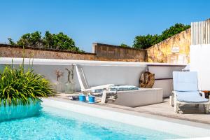 a swimming pool with two chairs and a table at Calçada in Alcácer do Sal