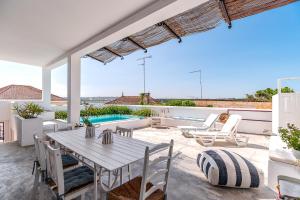 a patio with a table and chairs and a pool at Calçada in Alcácer do Sal