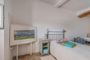 a white bedroom with a bed and a table at Calçada in Alcácer do Sal