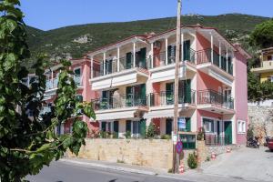 a pink building with balconies on a street at Apostolos Apartment 2 in Póndi +16 photos