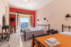 a bedroom with two beds and a balcony at Apostolos Apartment 2 in Póndi