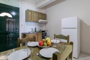 a kitchen with a table with a bowl of fruit on it at Apostolos Apartment 2 in Póndi