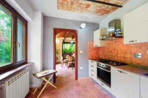 a kitchen with white cabinets and an open doorway at Il Trucchetto - Castagneto Po in Chivasso +26 photos