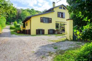 a yellow house with black windows and a gravel driveway at Il Trucchetto - Castagneto Po in Chivasso
