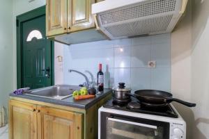 a kitchen with a sink and a stove with a pan on it at Apostolos Apartment 2 in Póndi