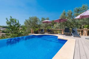 a swimming pool with chairs and umbrellas at Can Tamany in Port de Soller +10 photos