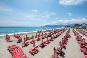 a beach with chairs and umbrellas and the ocean at Romantica e Accogliente Mansardina in Savona