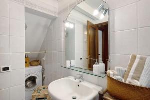 a bathroom with a sink and a mirror and a washing machine at Romantica e Accogliente Mansardina in Savona +26 photos