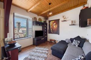 a living room with a couch and a tv at Romantica e Accogliente Mansardina in Savona