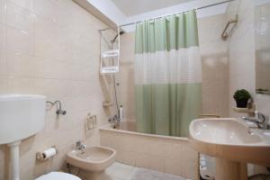 a bathroom with a toilet and a sink and a shower at T0 Grota in Buarcos +15 photos