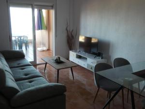 a living room with a couch and a table and a television at Marina Golf in Mojácar