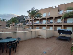 a patio with a table and chairs and a building at Marina Golf in Mojácar