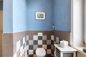 a bathroom with a toilet and a blue wall at Altes Pfarrhaus - Wohnung Farbwelt in Hüttenrode +16 photos