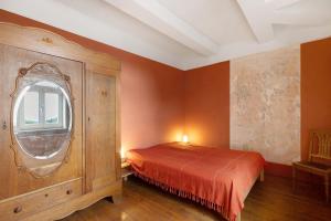 a bedroom with a bed and a round window at Altes Pfarrhaus - Wohnung Farbwelt in Hüttenrode