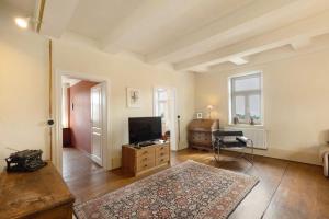 a living room with a television and a desk at Altes Pfarrhaus - Wohnung Farbwelt in Hüttenrode