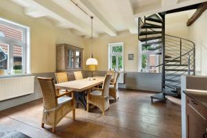 a dining room with a table and chairs and a spiral staircase at Altes Pfarrhaus - Wohnung Farbwelt in Hüttenrode