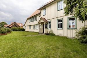 a house with a grass yard in front of it at Altes Pfarrhaus - Wohnung Farbwelt in Hüttenrode