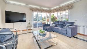 a living room with a couch and a tv at Costacabana - Villa Beyonce in Lloret de Mar