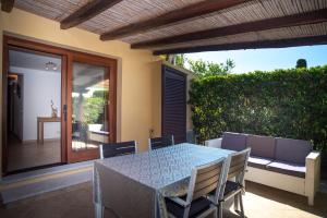 a patio with a table and chairs and a couch at Appartamento del Cormorano in Olbia