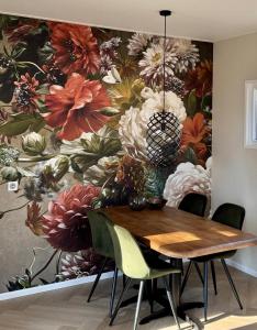 a dining room with a flower mural on the wall at Sallands Boschalet in Haarle +27 photos