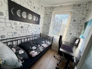 a bedroom with a bed and a desk and a window at Sterntaler Melsungen in Melsungen