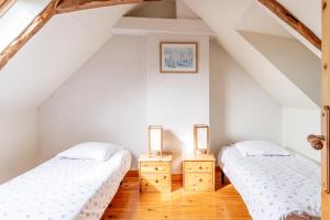 two beds in a attic room with two lamps at Ville Daniel in Pordic