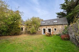 a stone house with a picnic table in a yard at Ville Daniel in Pordic