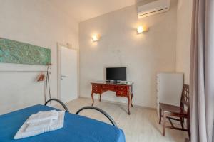 a room with a bed and a desk with a television at Anghelos in Lizzanello