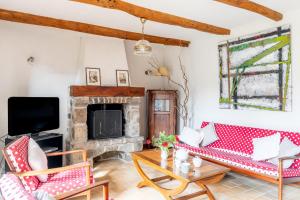 a living room with red and white furniture and a fireplace at Ville Daniel in Pordic