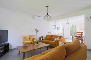a living room with two couches and a tv at Maison familiale Kerriou in Plestin-les-Grèves
