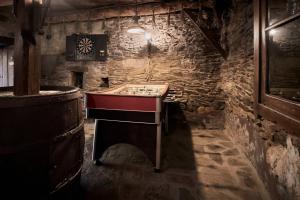 a room with a chess table in a stone wall at El Pajariel ll in Valdecañada +21 photos