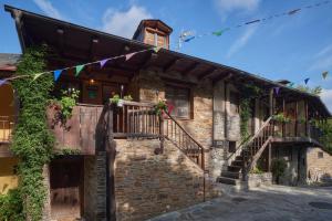 a stone house with stairs and a balcony at El Pajariel ll in Valdecañada
