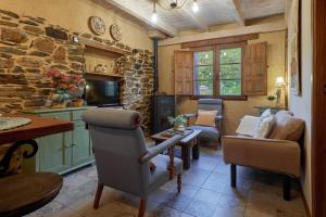 a living room with chairs and a stone wall at El Pajariel ll in Valdecañada