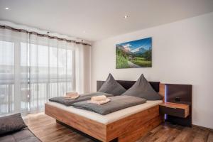 a bedroom with a bed and a large window at Ferienwohnung Legau in Legau