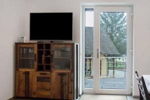 a living room with a television and a sliding glass door at Mohnblume in Unterwittighausen
