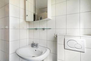 a white bathroom with a sink and a mirror at Ferien am Lipbachpark in Friedrichshafen