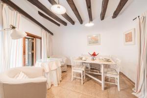 a white dining room with a table and chairs at La Sastreria in Pollença
