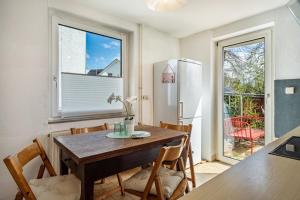 a kitchen with a table and chairs and a refrigerator at Ferien am Lipbachpark in Friedrichshafen