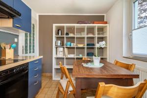 a kitchen with a wooden table and chairs in a kitchen at Ferien am Lipbachpark in Friedrichshafen +15 photos