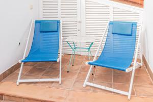 two blue chairs and a table on a balcony at La Sastreria in Pollença