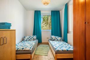 a room with two beds and a window with blue curtains at Ferien am Lipbachpark in Friedrichshafen