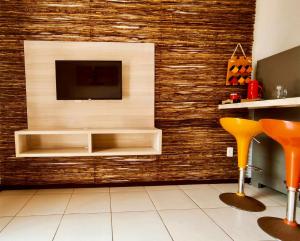 a living room with a tv on a wall at Hotel Natal Ponta Negra Sun in Natal
