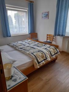 a bedroom with a bed with blue curtains and a window at Casa Defrancesco - with Garden in Moena